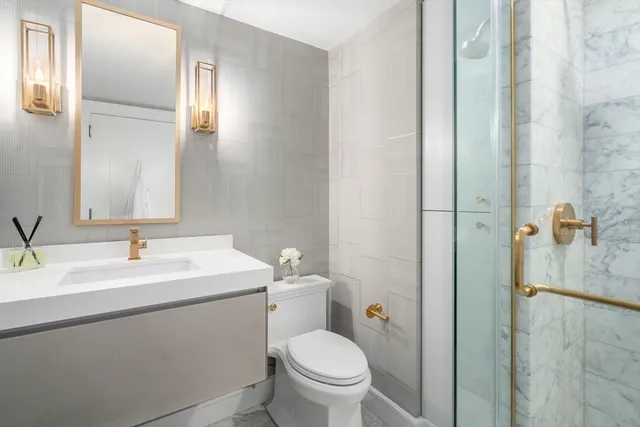 a bathroom with a toilet sink and mirror