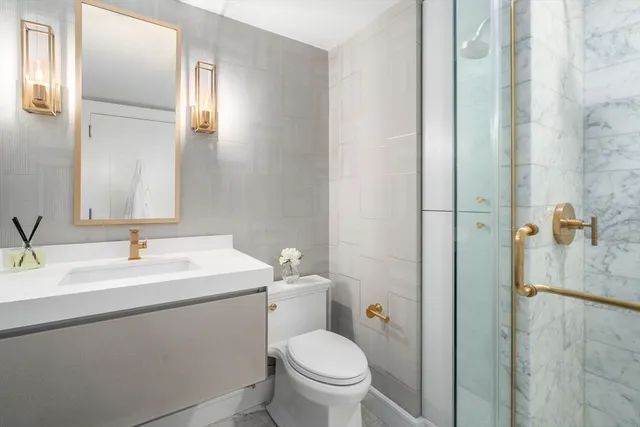 a bathroom with a toilet sink and mirror