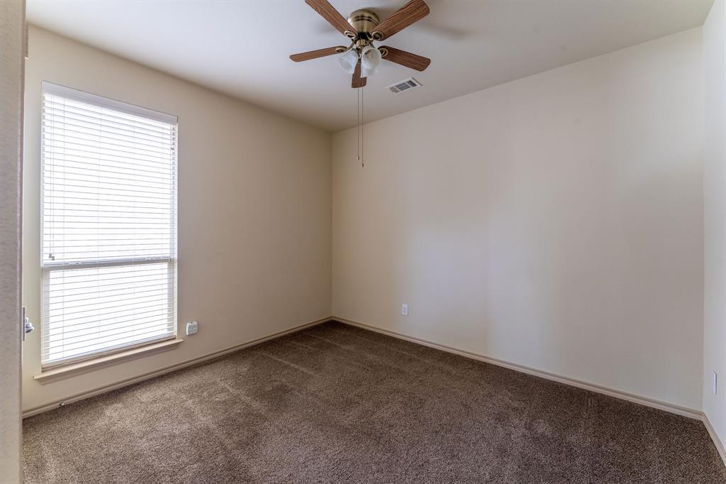 11156 Hawks Landing Road Fort Worth, TX 76052 - Photo 12 of 30 Neutral wall tones featuring a window with horizontal blinds, overhead ceiling fan with wood-finish blades, and brown carpet flooring