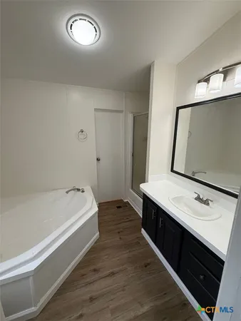 a spacious bathroom with a tub sink and mirror