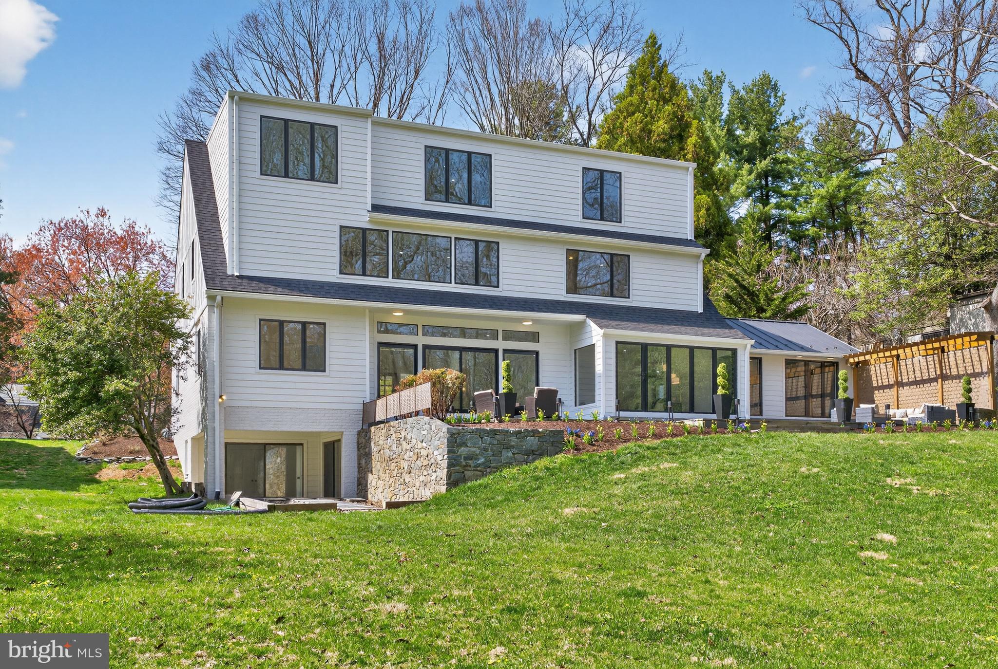 7126 Darby Road Bethesda, MD 20817 - Photo 77 of 84 a front view of a house with a garden and trees