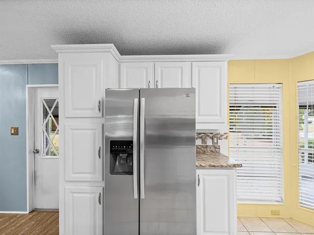 a kitchen with stainless steel appliances a refrigerator and a window