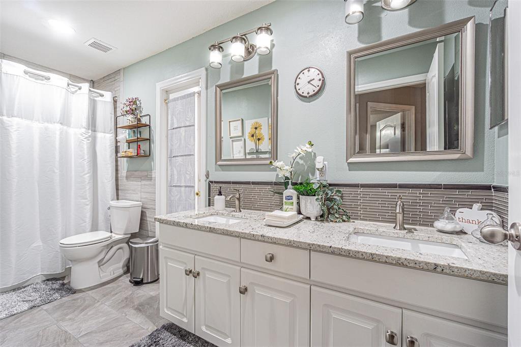 9809 La Rita Place Riverview, FL 33569 - Photo 16 of 59 a bathroom with a granite countertop toilet sink double vanity and a mirror
