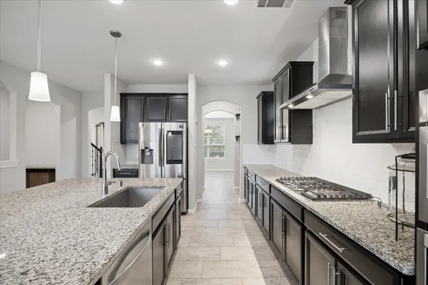 a kitchen with stainless steel appliances granite countertop a sink stove and refrigerator
