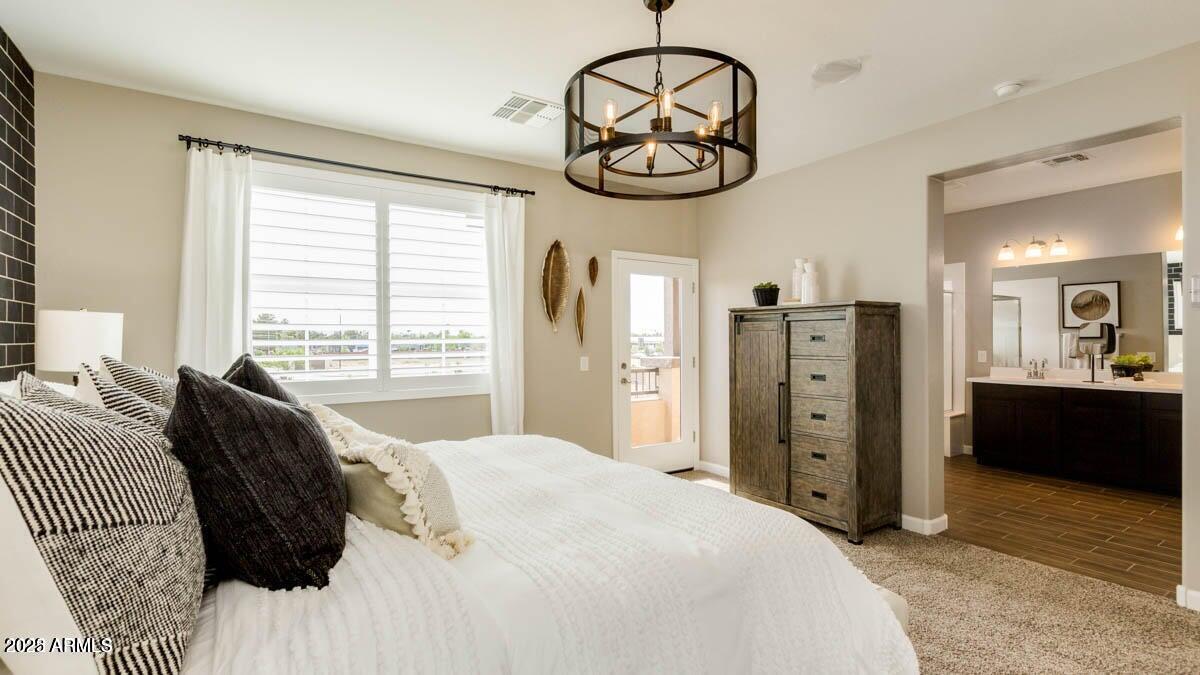 1255 North Arizona Avenue, Unit 1314 Chandler, AZ 85225 - Photo 16 of 23 a bedroom with a bed and a chandelier