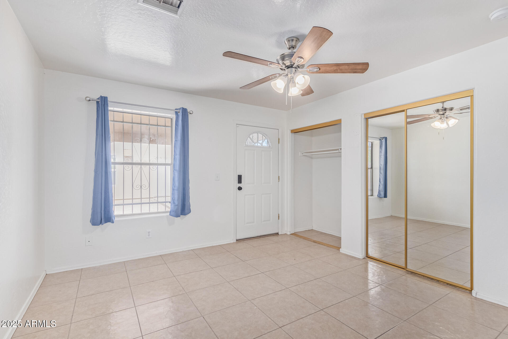 2118 West Adams Street Phoenix, AZ 85009 - Photo 11 of 48 a view of an empty room with window and chandelier fan