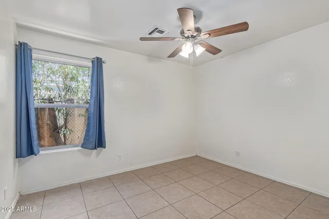 a view of an empty room and chandelier fan