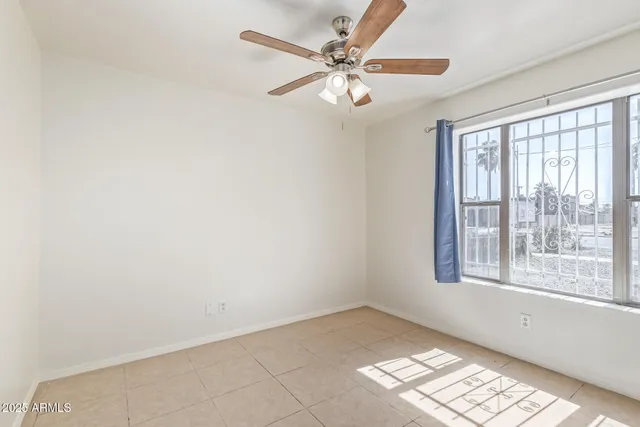 an empty room with a ceiling fan and a window