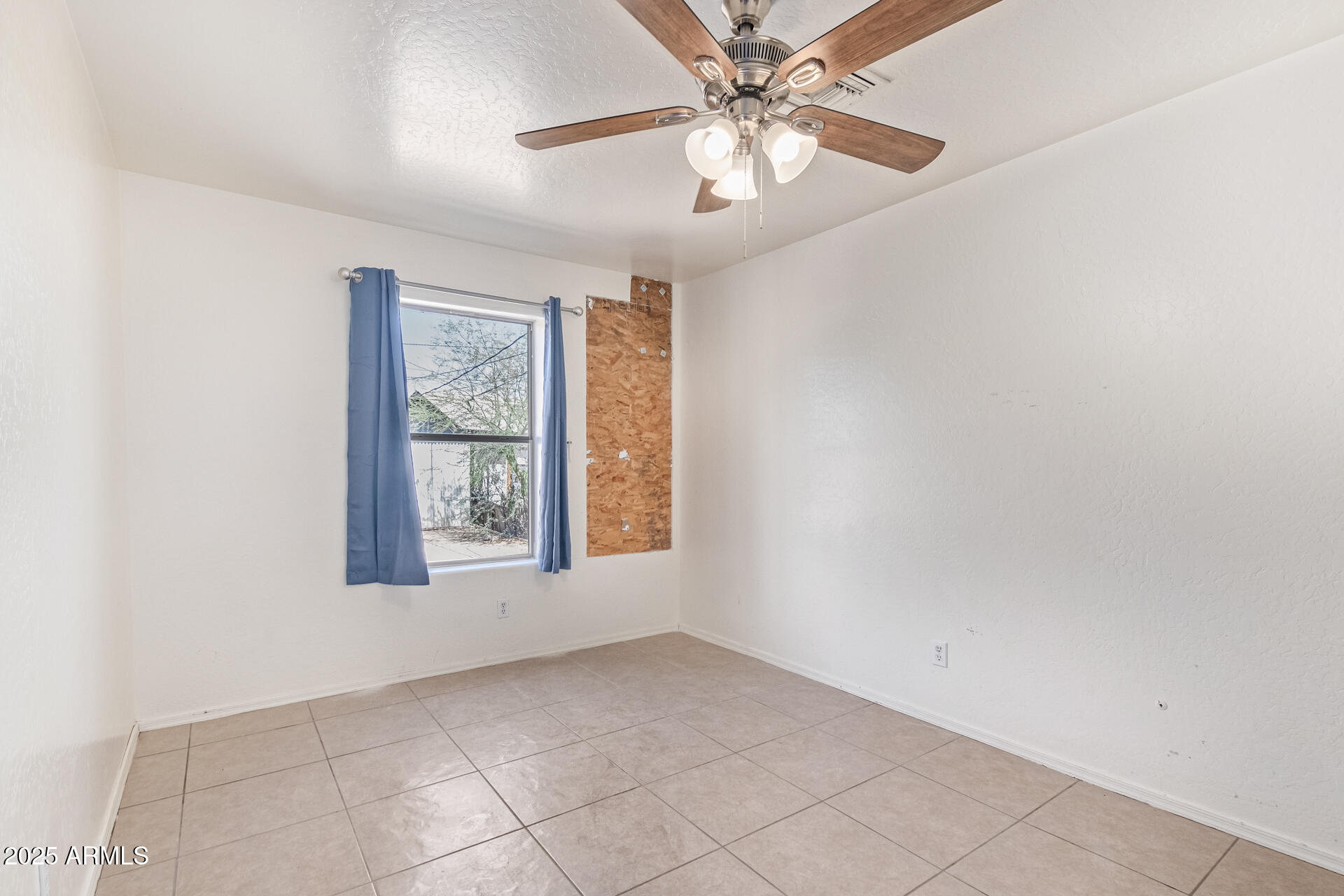 2118 West Adams Street Phoenix, AZ 85009 - Photo 22 of 48 an empty room with chandelier fan and windows