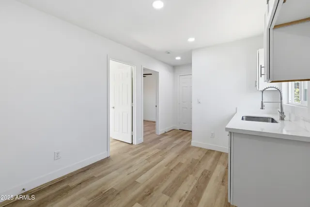 a room with a sink cabinets and wooden floor