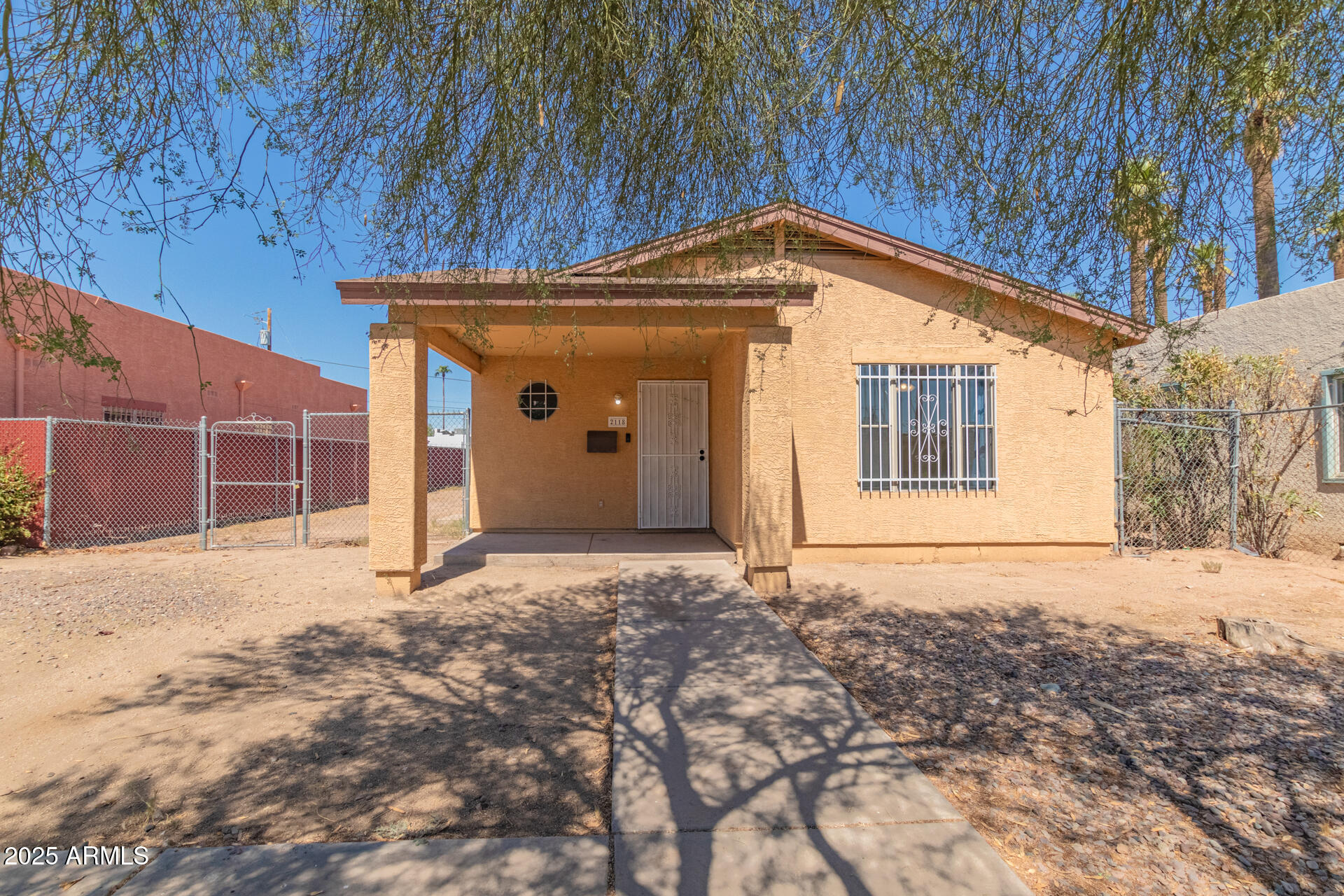 2118 West Adams Street Phoenix, AZ 85009 - Photo 3 of 48 a view of a house with a wooden fence