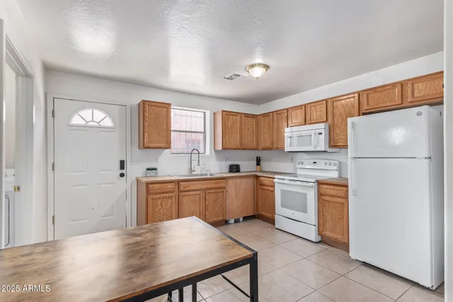 a kitchen with white cabinets and white appliances