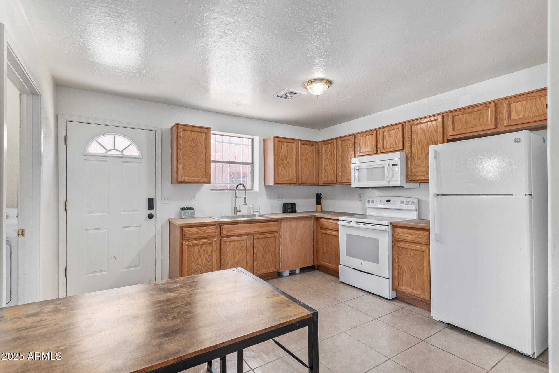 2118 West Adams Street Phoenix, AZ 85009 - Photo 9 of 48 a kitchen with a white refrigerator a sink dishwasher with a dining table and chairs