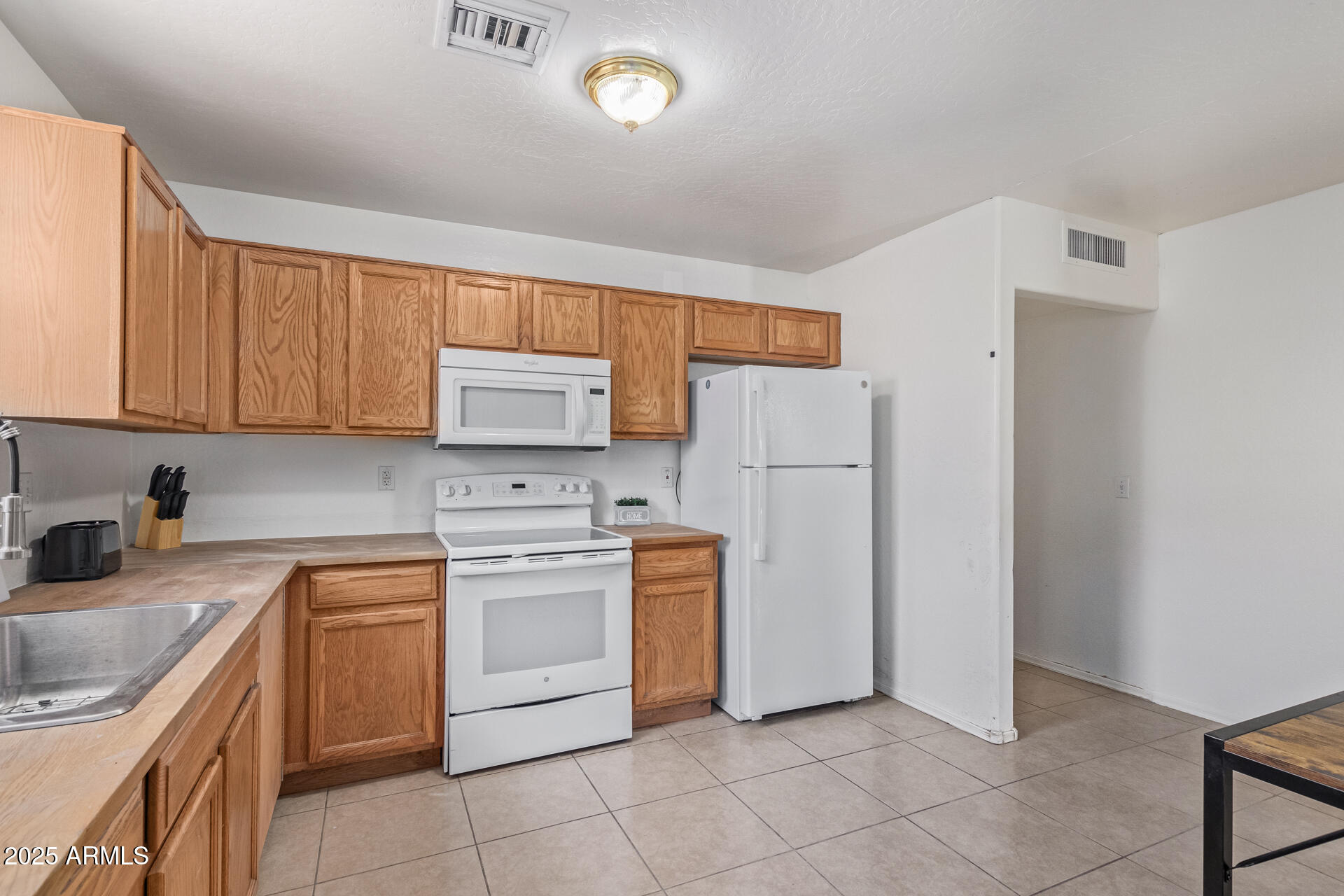 2118 West Adams Street Phoenix, AZ 85009 - Photo 10 of 48 a kitchen with white cabinets and white appliances