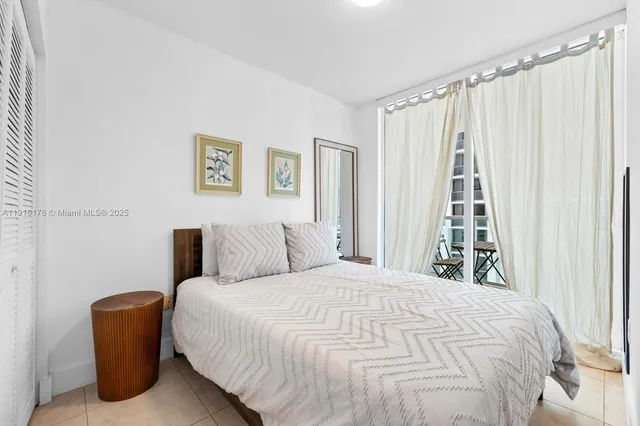 a large bed sitting in a bedroom next to a window