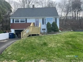 a view of a house with a big yard plants and large tree