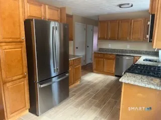 a kitchen with stainless steel appliances granite countertop a refrigerator and a stove