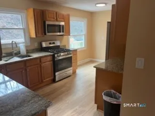 a kitchen with stainless steel appliances granite countertop a stove a sink and a microwave