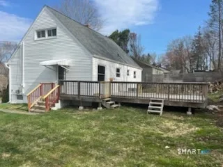 a view of a house with a yard and a wooden deck