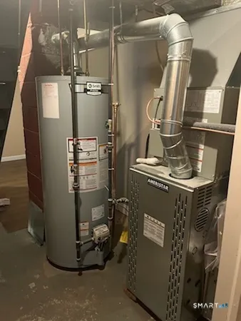 a room with water heater and wooden cabinets