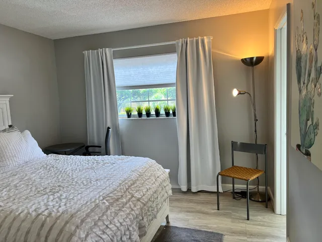 a bedroom with a bed a mirror and a window