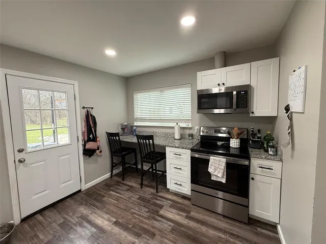 a kitchen with stainless steel appliances a stove a sink a microwave a refrigerator and cabinets