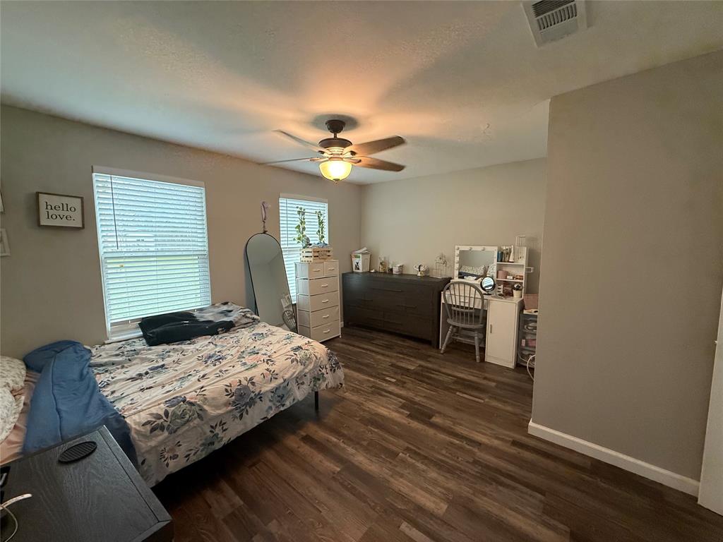 124 Cedar Street Waco, TX 76705 - Photo 7 of 12 a bedroom with a bed and a chandelier