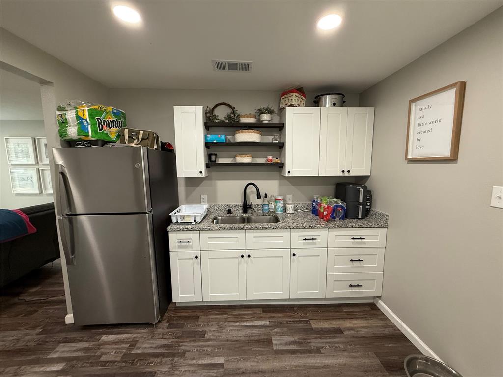 124 Cedar Street Waco, TX 76705 - Photo 9 of 12 a kitchen with stainless steel appliances a refrigerator sink and cabinets