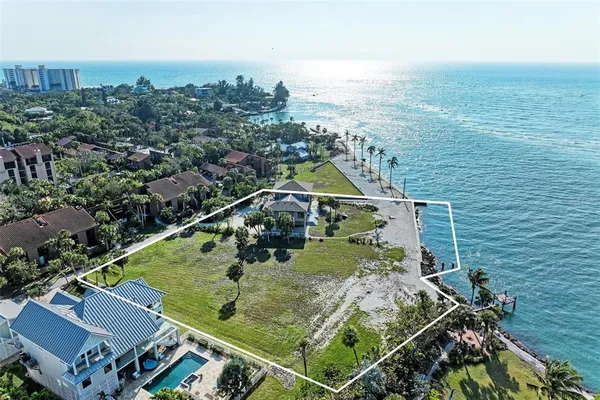 an aerial view of residential houses with outdoor space and ocean view