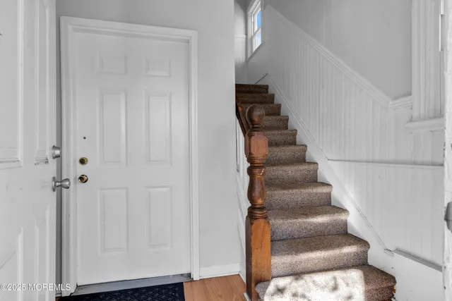 a view of entryway and hall with wooden floor