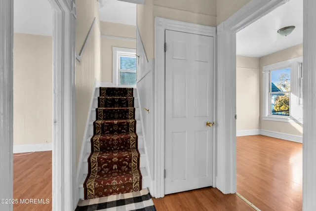 a view of a hallway with wooden floor windows and livingroom
