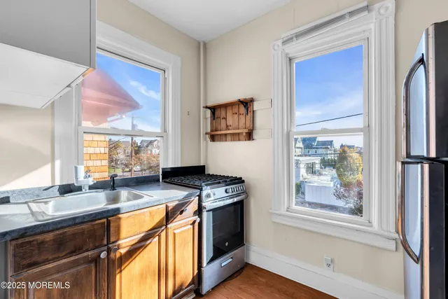 a kitchen with stainless steel appliances granite countertop a stove a sink and a microwave