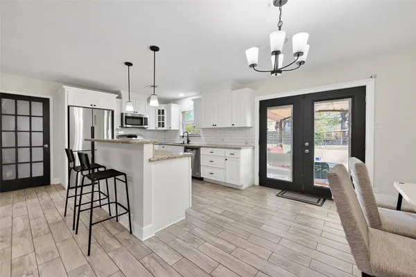 a kitchen with granite countertop white cabinets and stainless steel appliances