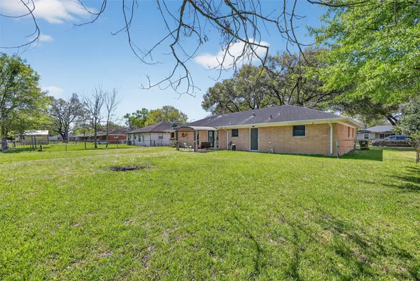 a view of a house with a big yard and a large tree