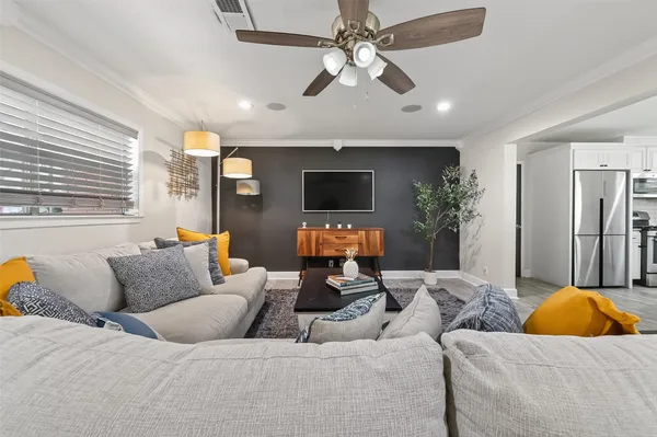 a living room with furniture a flat screen tv and a clock