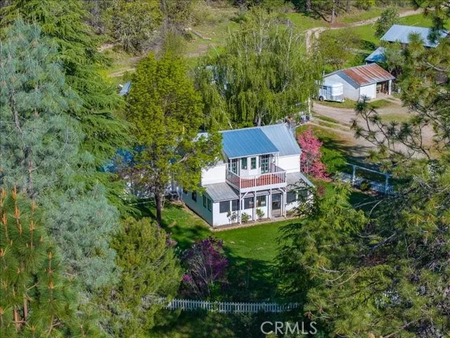 an aerial view of a house with garden space and trees