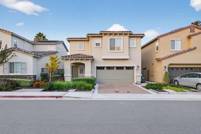a front view of a house with yard and parking
