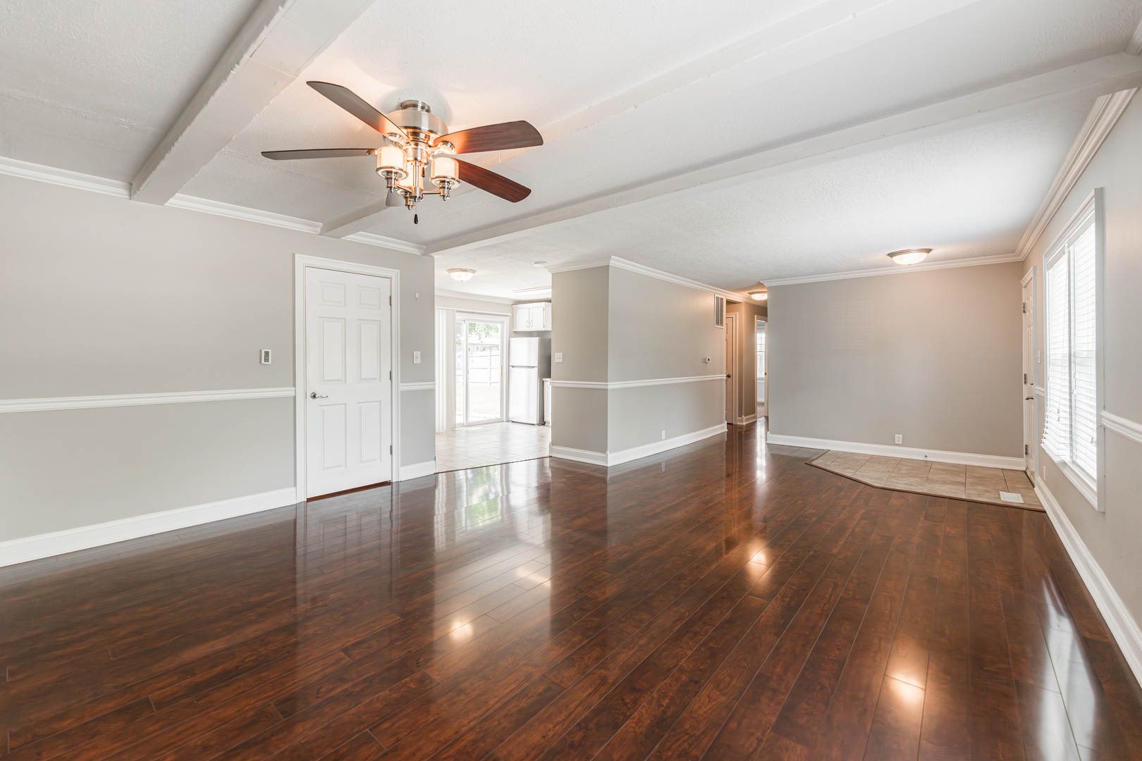 1614 East Dresser Road DeKalb, IL 60115 - Photo 4 of 26 a view of an empty room with wooden floor and a ceiling fan