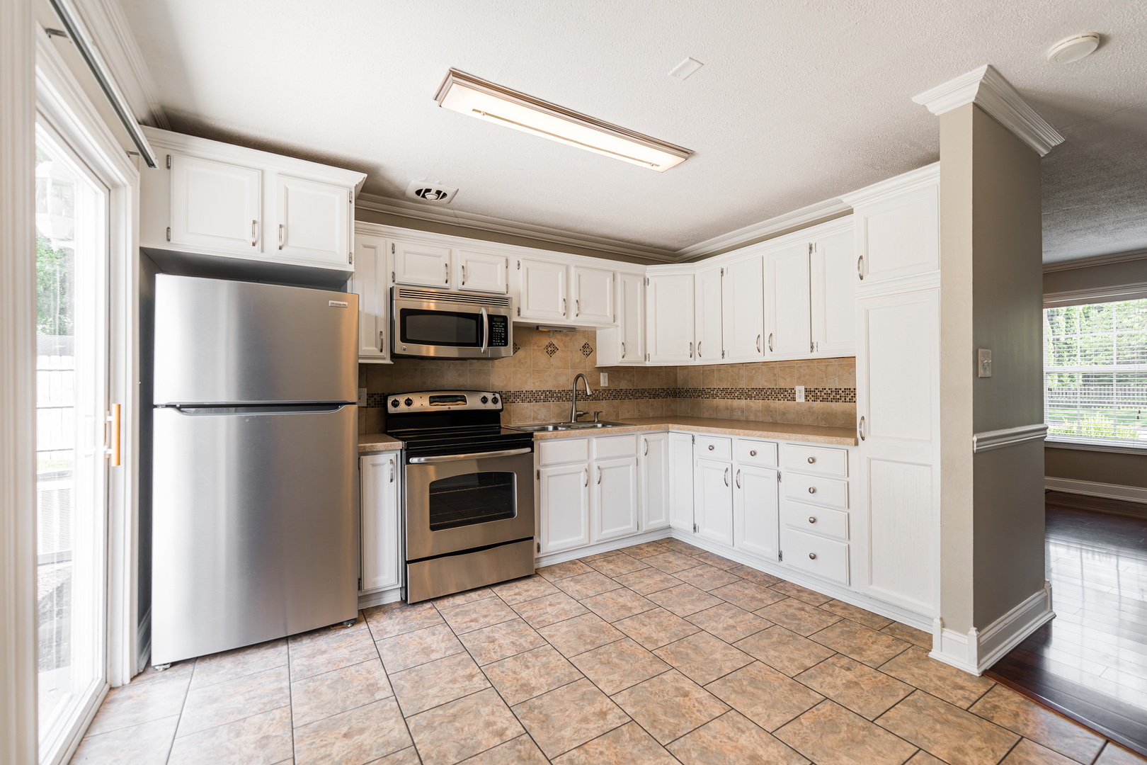 1614 East Dresser Road DeKalb, IL 60115 - Photo 7 of 26 a kitchen with cabinets stainless steel appliances and a window
