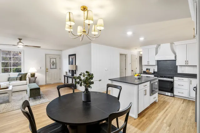 a kitchen with stainless steel appliances granite countertop a stove a kitchen island a dining table and chairs