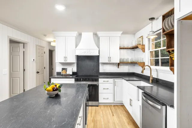a kitchen with stainless steel appliances a stove a sink and a refrigerator