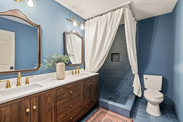a bathroom with a granite countertop sink toilet and shower