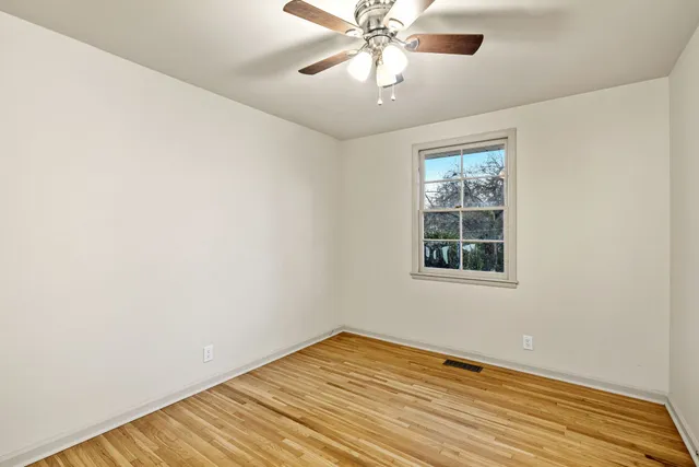 an empty room with a window and wooden floor