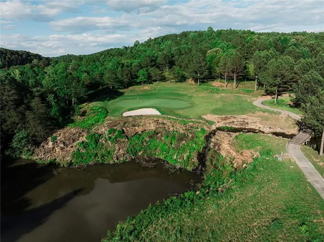 an aerial view of a golf course with a lake view