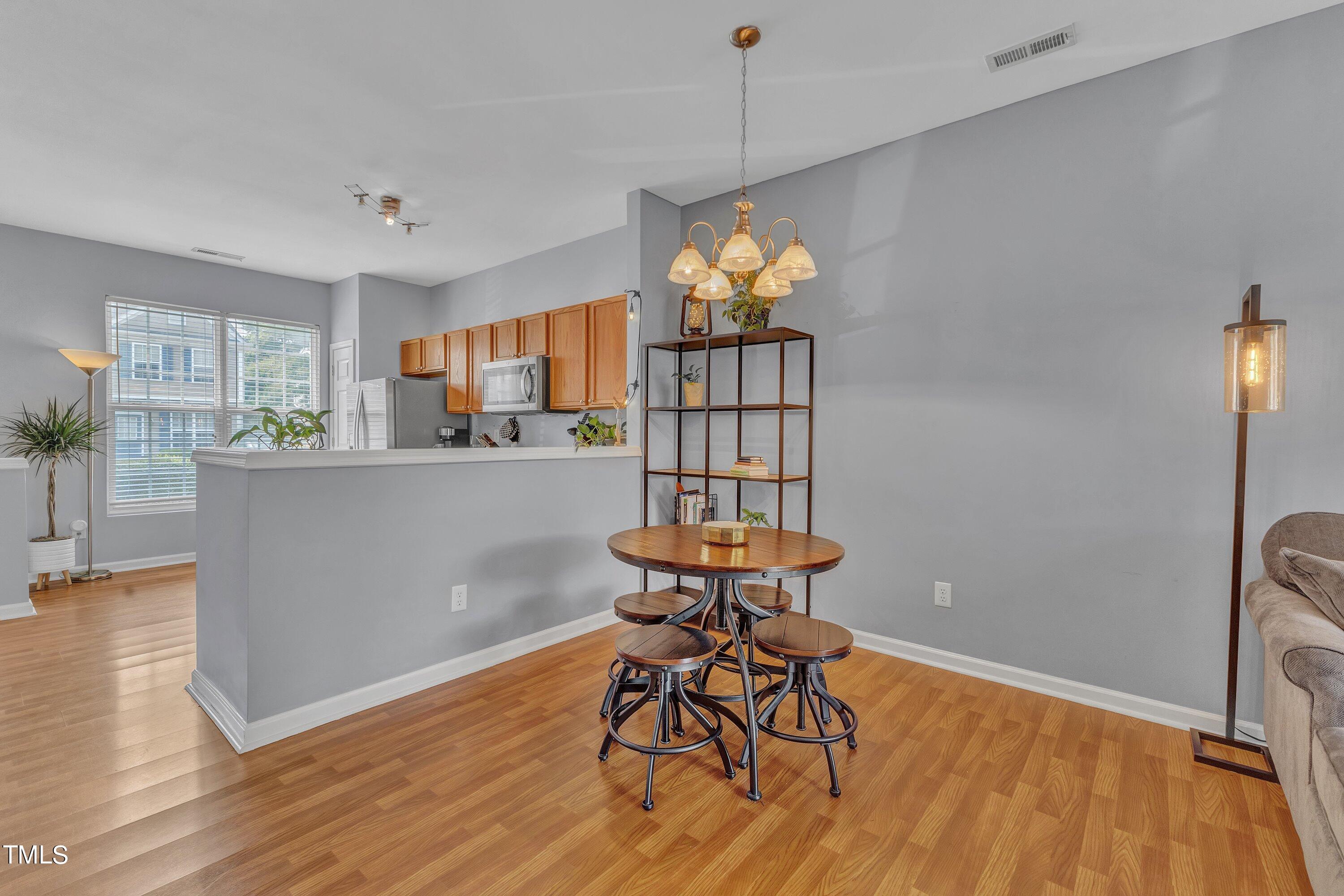 1743 Sorrell Brook Way Raleigh, NC 27609 - Photo 11 of 30 a dining room with furniture a chandelier and wooden floor