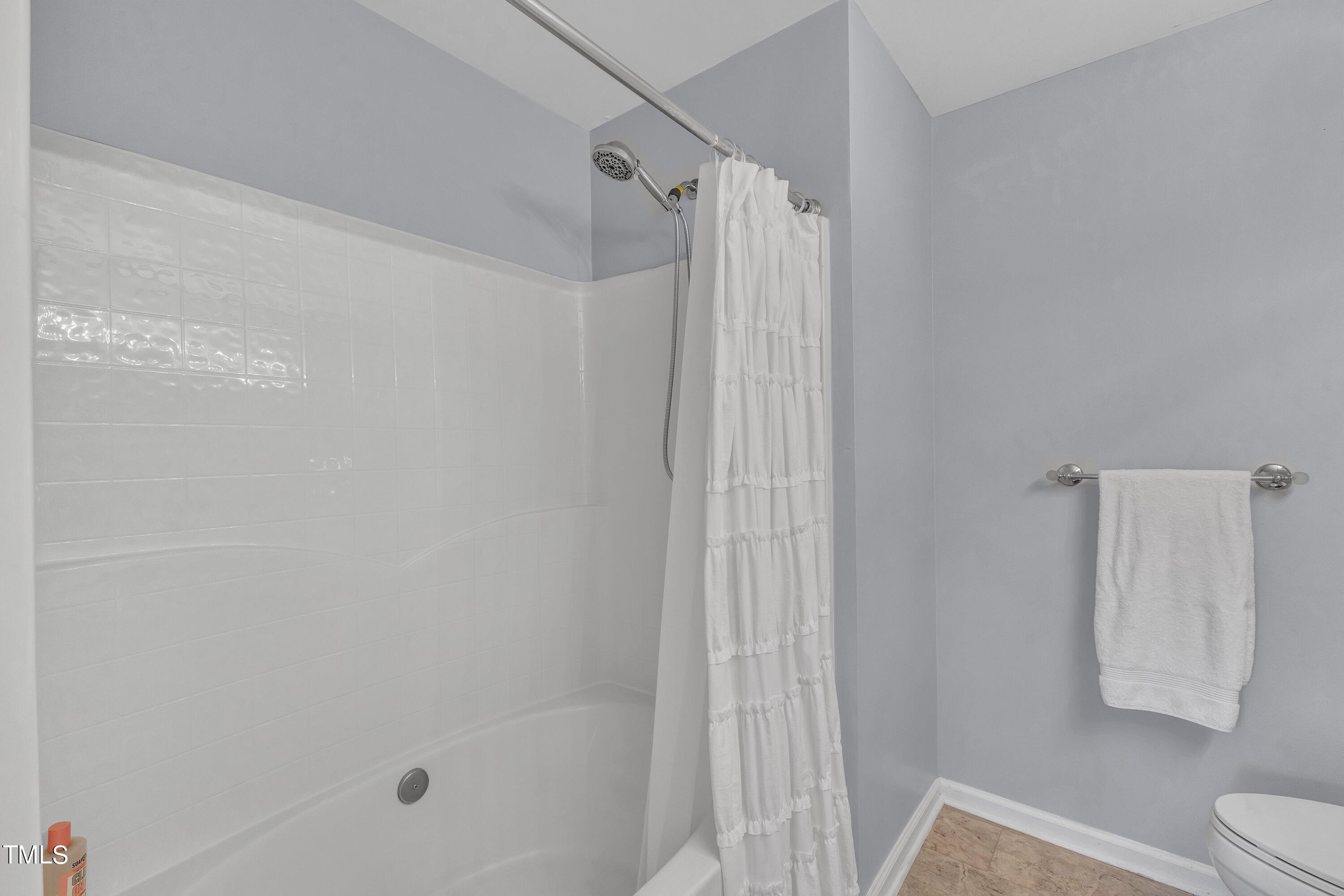 1743 Sorrell Brook Way Raleigh, NC 27609 - Photo 21 of 30 a bathroom with a shower curtain and a sink
