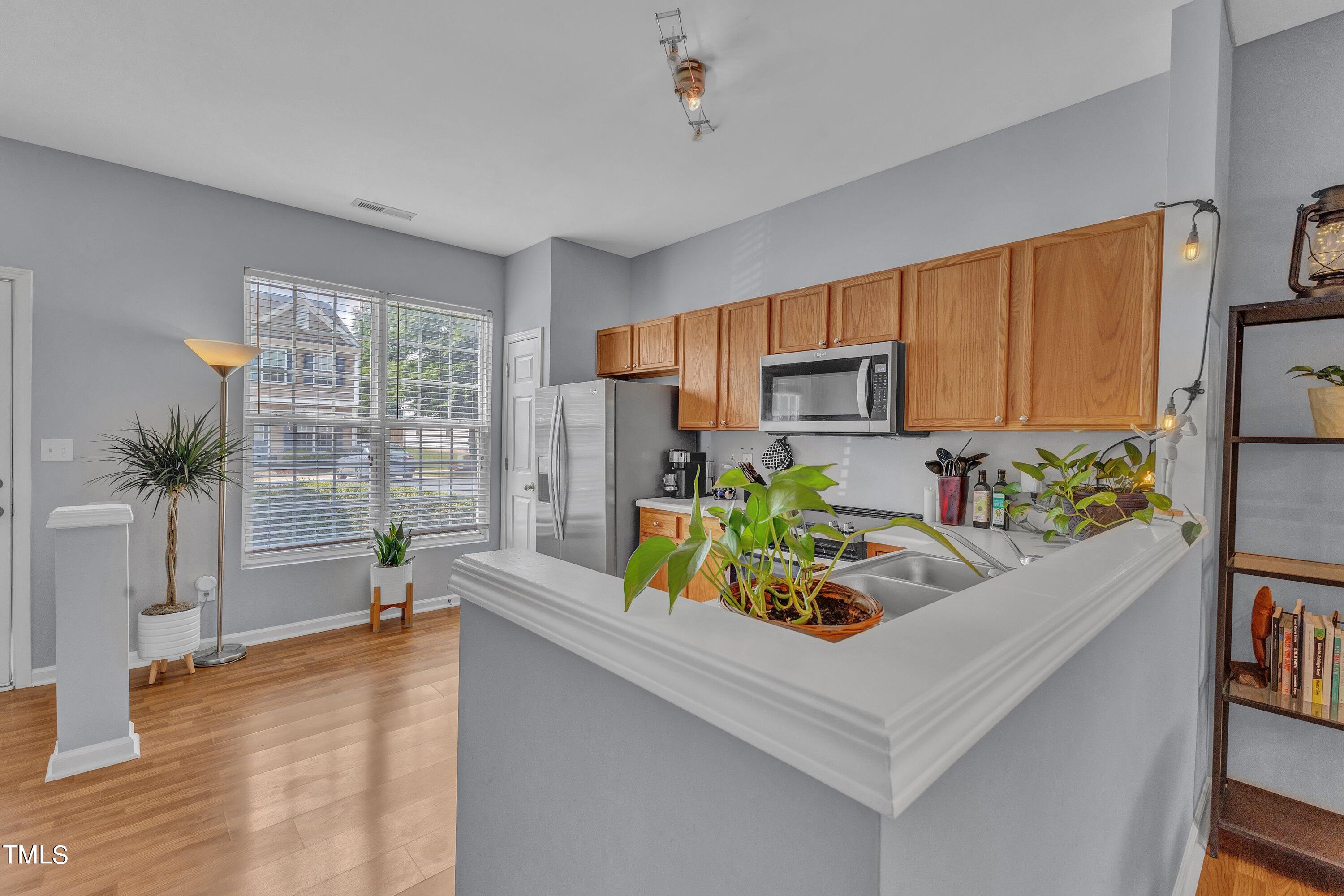 1743 Sorrell Brook Way Raleigh, NC 27609 - Photo 10 of 30 a kitchen with stainless steel appliances a sink a counter top space and a window