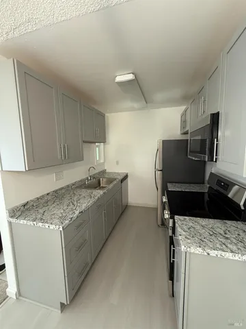 a kitchen with stainless steel appliances granite countertop a sink stove and refrigerator