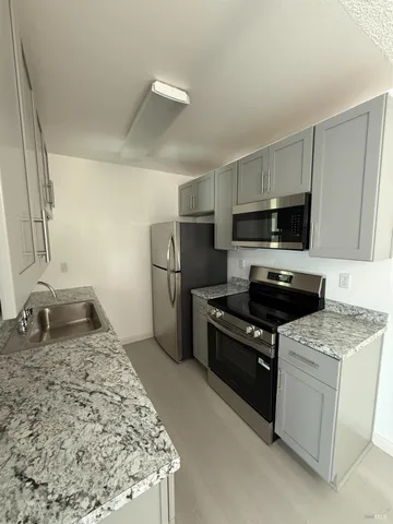 a kitchen with a stove a refrigerator and a sink