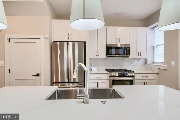 a kitchen with stainless steel appliances a refrigerator sink and stove